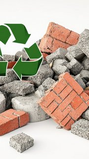 Recyclable construction debris pile with a green recycle symbol.  Pieces of broken bricks and concrete, signifying waste material