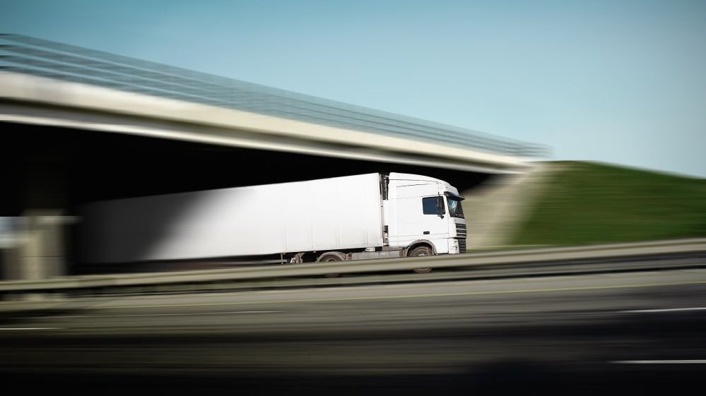 LKW fährt unter einer Brücke durch