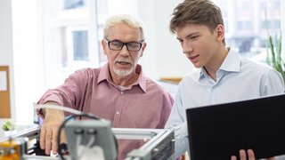 Pleasant senior engineer teaching about 3D printer