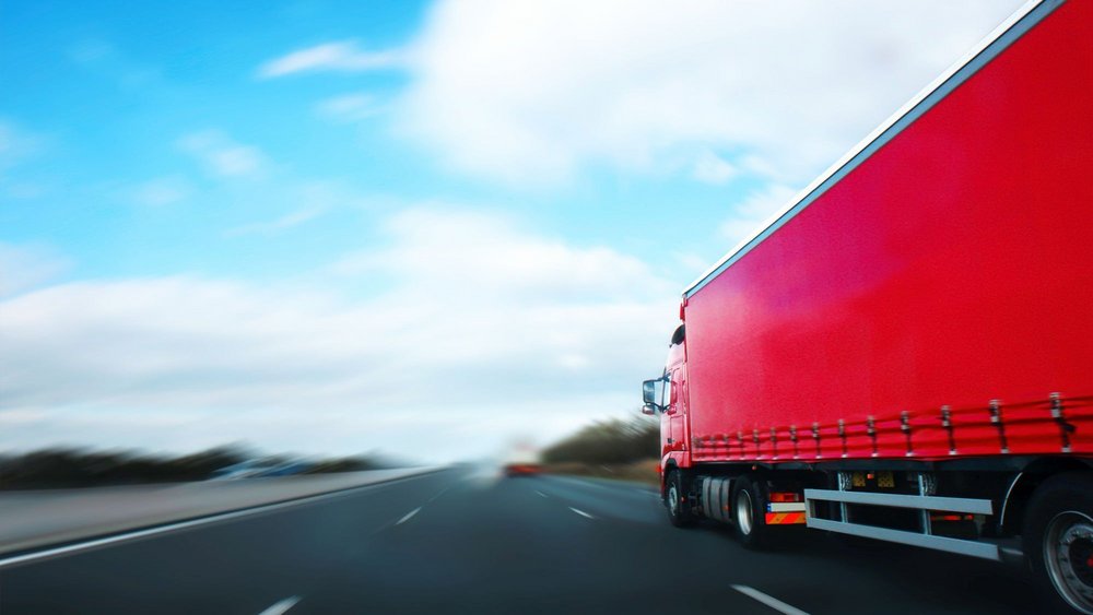 Roter Lastwagen unterwegs auf der Autobahn