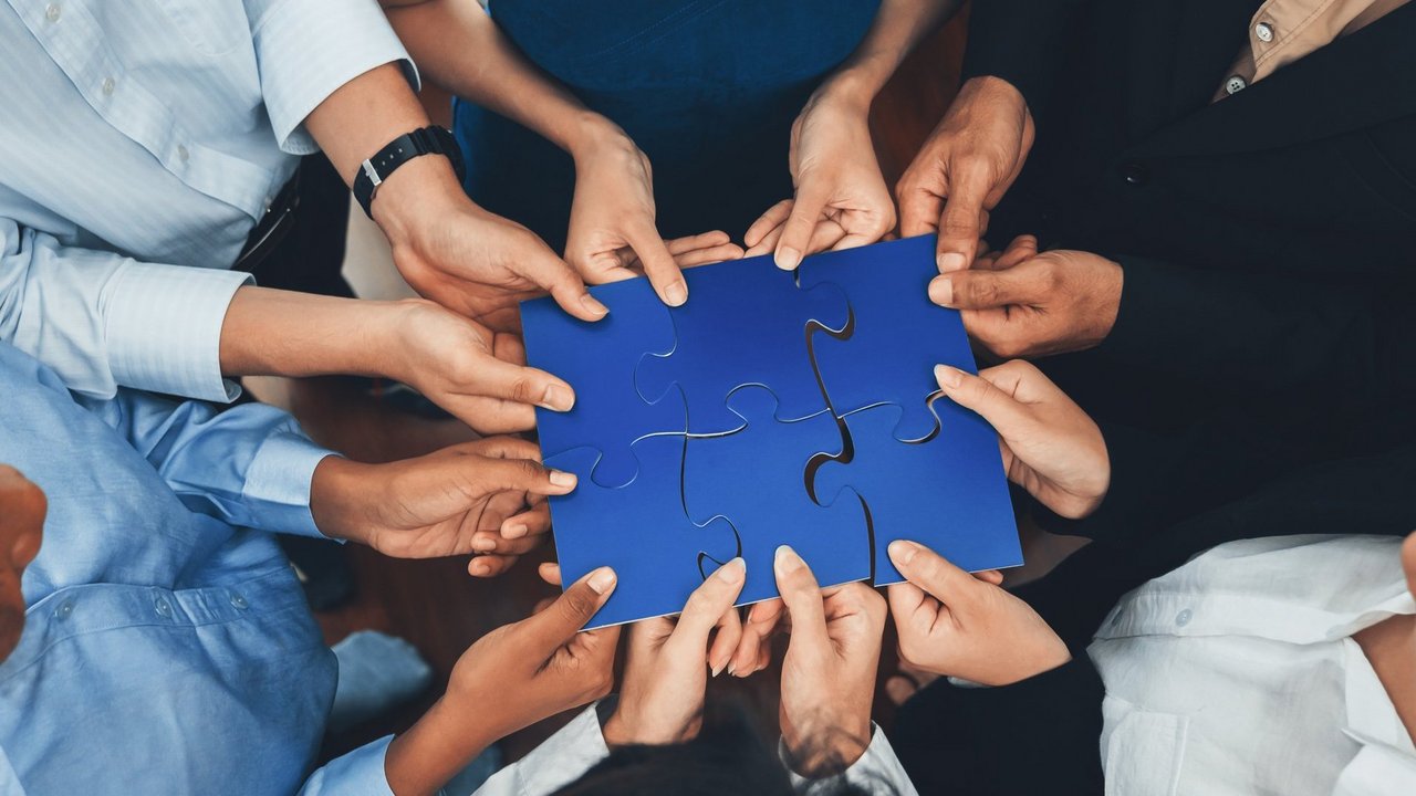 Diverse corporate officer workers connecting puzzle pieces. Concord
