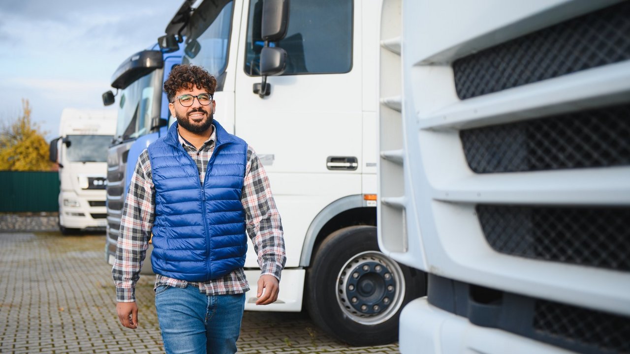 Young man truck driver walking near semi trucks