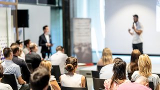 Male business speaker giving a talk at business conference event. Male business speaker giving a talk at business conference event.