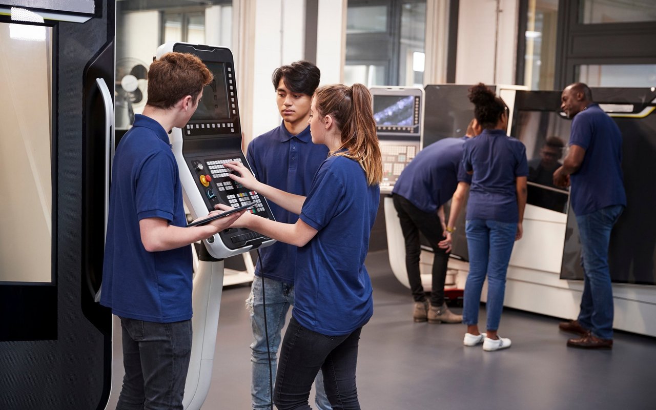 Engineer Showing Apprentices How To Use CNC Tool Making Machine