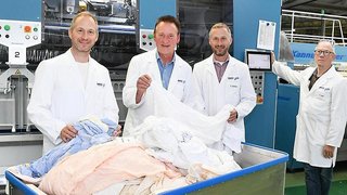 Die Geschäftsführer der Johann Hitz GmbH – Textile Dienstleistungen in Fürth, Dr. Elmar Dohnke (l.) und Christof Dohnke (2. v. r.), mit Fürths Oberbürgermeister Dr. Thomas Jung (2. v. l.) und Seniorchef Hans Keil vor der neuen Taktwaschanlage.