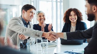 Happy, business people and applause with handshake for good deal, partnership or agreement at conference. Businessman, colleagues or employees shaking hands with team for introduction at workplace