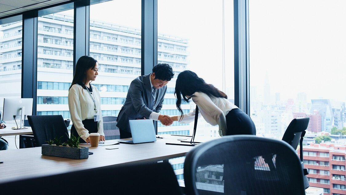 Japanese, business and people bow with handshake for meeting introduction, partnership and recruitment. Staff, welcome and respect for negotiation, investment deal and onboarding opportunity in Japan