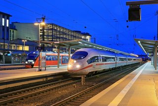 Im abendlichen Aschaffenburg Hbf wartet ein ICE 3 Baureihe 403  "Konstanz" auf Abfahrt als ICE 821 von Oberhausen nach Würzburg  Hbf. Dahinter steht ein Dieseltriebwagen der Baureihe VT 642 der  Westfrankenbahn, der aus Miltenberg angekommen ist.