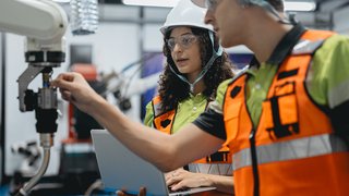 Smart Latino woman and male colleague working on AI technology in robotic electronic engineering laboratory. Hispanic engineer technician team research in robot machine futuristic automated control.