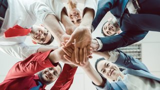 Team of diverse business people stacking their hands together